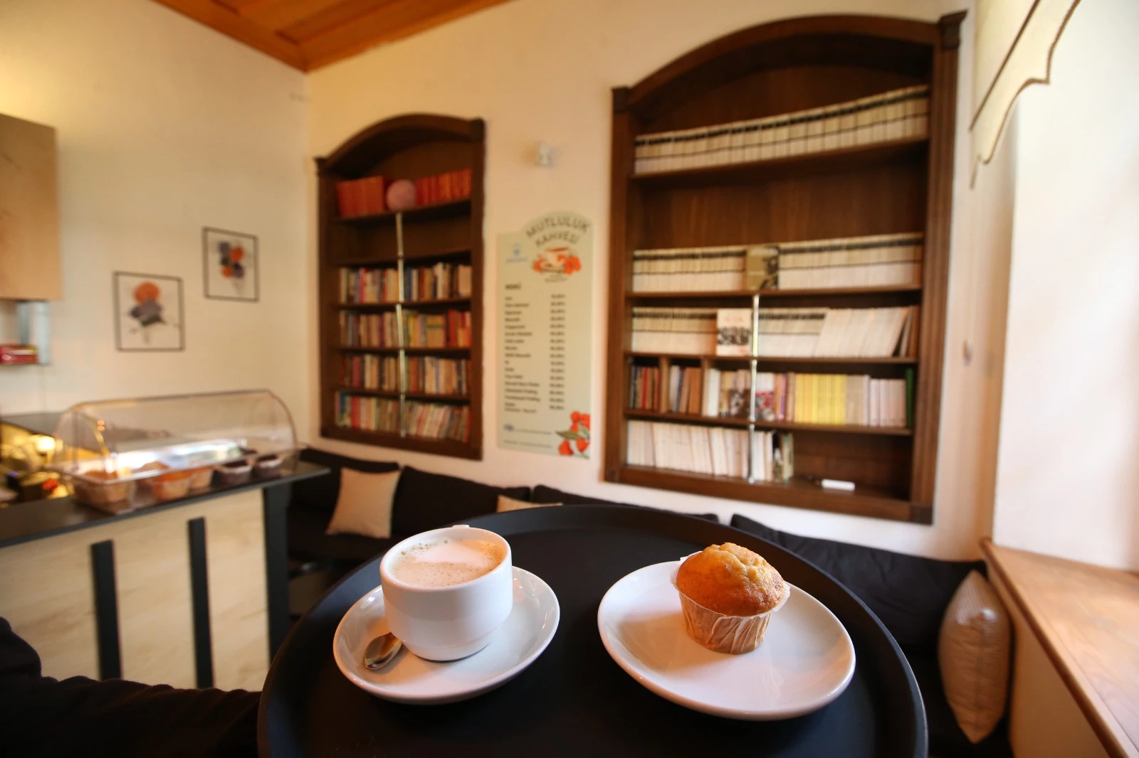 Adile Naşit Parkı Mutluluk Kahvesi'nin kitaplıklı salonunda kahve ve muffin